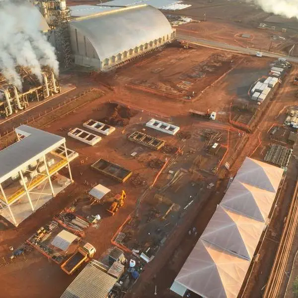 Vista aérea da usina em obra, com galpões e armazém em arco